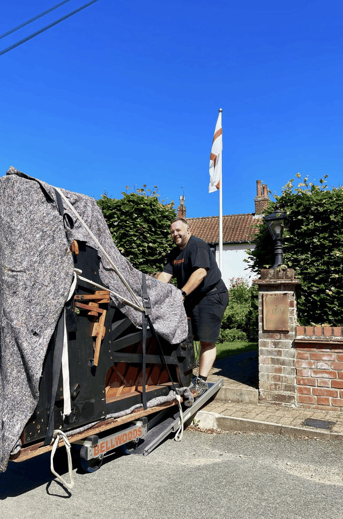 Bellwoods crew member with a strapped piano on a skate, England flag behind